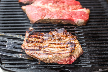 Beef steaks on grill or BBQ with spatula