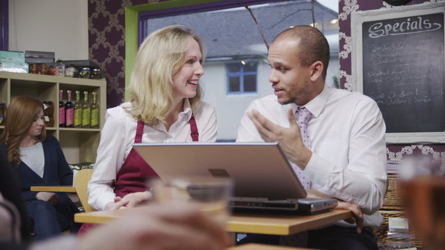 Happy Female Coffee Shop Worker In An Informal Meeting With Her Employer.