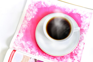 A cup of hot coffee and a magazine