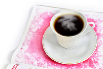 A cup of hot coffee and a magazine