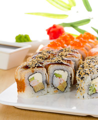Sushi set on white plate over wooden background