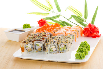 Sushi set on white plate over wooden background