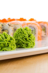 Sushi set on white plate over wooden background