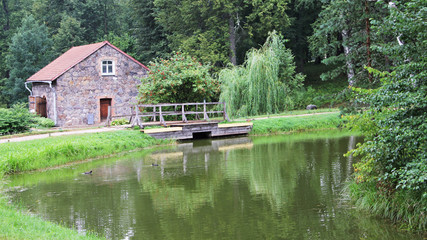 Fototapeta na wymiar Stone building on the shore of the pond. Mikhailovskoye