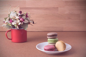 Frence sweet delicacy macaroons and white coffee cup on wood bac