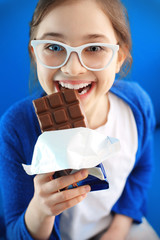 Kocham czekolade... Dziewczynka gryzie tabliczkę czekolady