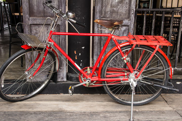 Fototapeta na wymiar vintage red bicycle on vintage wooden house wall