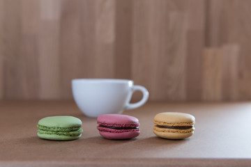 Frence sweet delicacy macaroons and white coffee cup on grunge