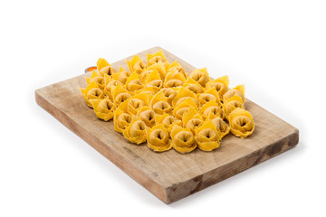 Ravioli freschi crudi su un asse di legno 