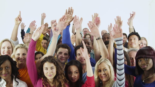 Happy, diverse group in casual clothing raise their hands