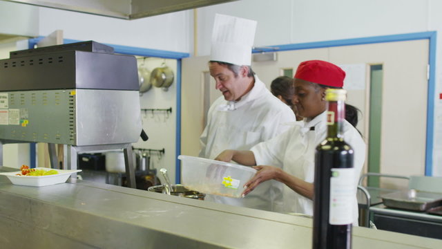 Team of professional chefs preparing food in a hotel or restaurant kitchen