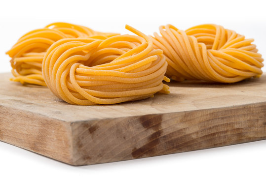 Spaghetti di pasta fresca all&rsquo;uovo arrotolati su tagliere di leg