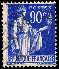 Stamp printed in France shows a woman with Olive Branch