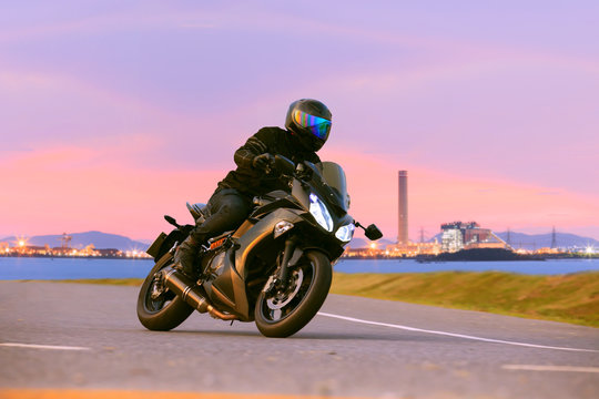 Fototapeta young man riding sport touring motorcycle on asphalt highways ag