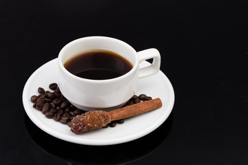 Cup of coffee with sugar stick, on black with clipping path