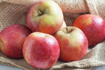 Fototapeta na wymiar Pommes bicolores sur toile de jute