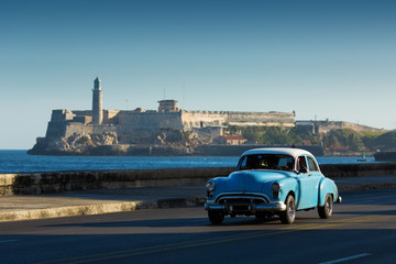 Vieille voiture classique dans la rue de La Havane avec océan et phare dedans