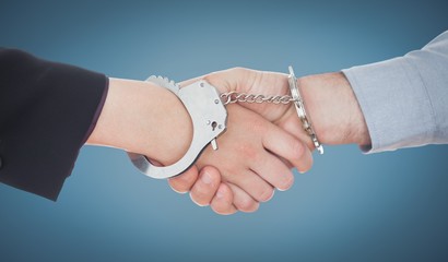 Composite image of business people in handcuffs shaking hands