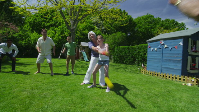 Family and friends of many generations playing sports in the garden on a sunny day