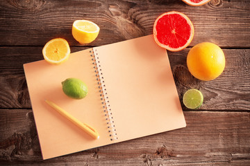 citrus with notebook on old wooden table