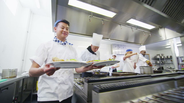 Team of professional chefs preparing food in a commercial kitchen