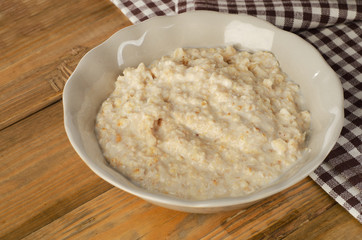 Bowl of oatmeal on old wooden table. Healthy traditional breakfa