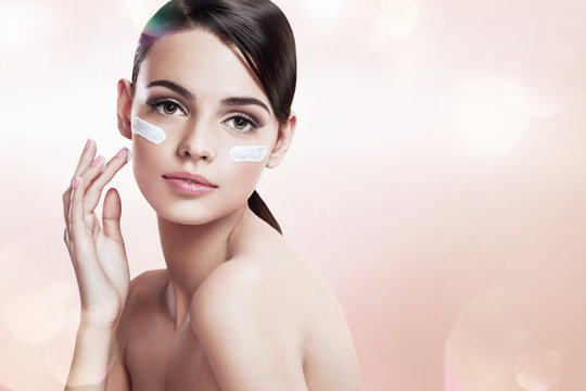 Skin care teenage girl putting face cream