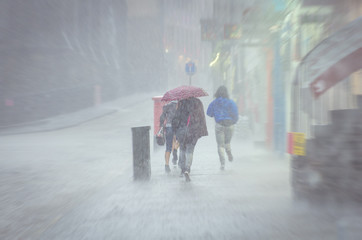 Group of girls walking at summer rain in the city