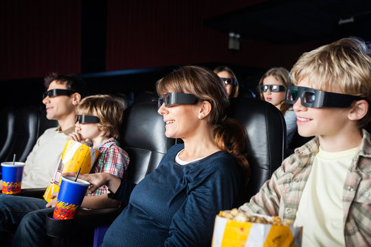 Smiling Families Watching 3D Movie In Theater