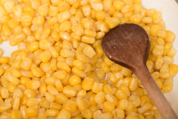 cooking sweet conn with wooden spoon