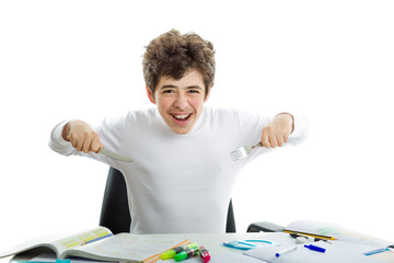 Boy doing homework with fork and knife