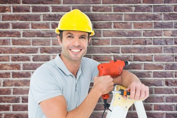 Happy technician holding drill machine while leaning on ladder