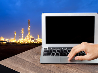 Engineer using a laptop at factory, plant background