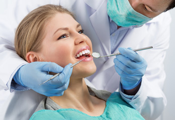 Gingivitis therapy. Male surgeon examining female's molar - 80574727