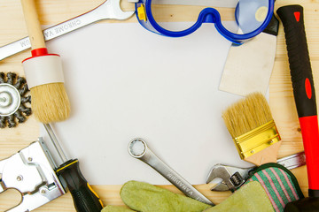 Paper for notes and set of working tools on wooden background.