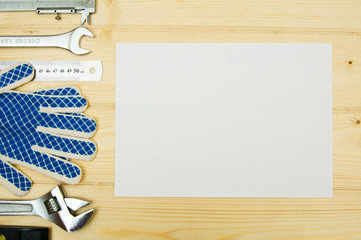 Paper for notes and set of working tools on wooden background.