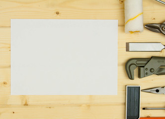 Paper for notes and set of working tools on wooden background.