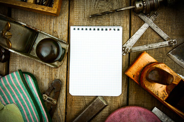 Fototapeta na wymiar Paper with pencil and the vintage working tools on wooden