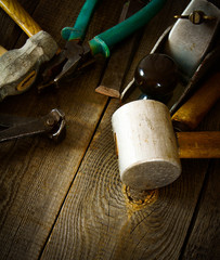 Many old working tools ( mallet, pliers and others) on a wooden