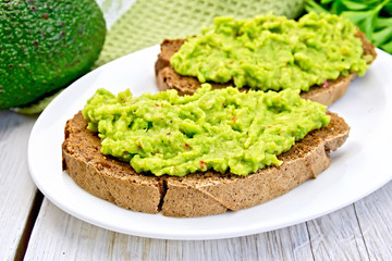 Sandwich with avocado guacamole on light board