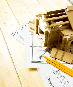 Many drawings for building, pencils and small house on wooden