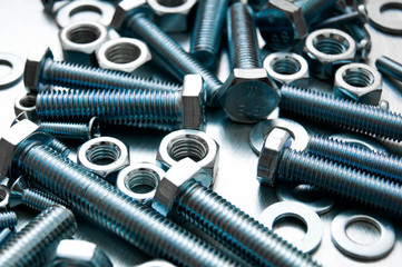 Nuts, washers and bolts on scratched metal background.