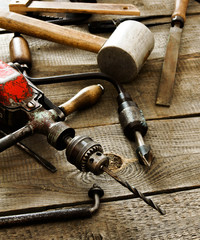 Many old working tools (drill, pliers and others) on a wooden