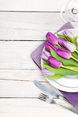 Purple tulip bouquet over plate