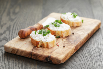 Fototapeta na wymiar crunchy baguette slices with cream cheese and green onion on