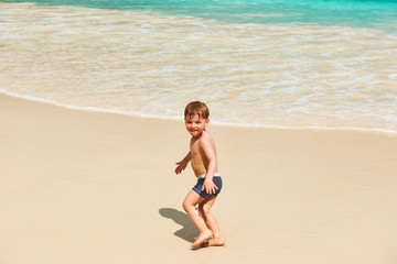 Two year old boy playing on beach
