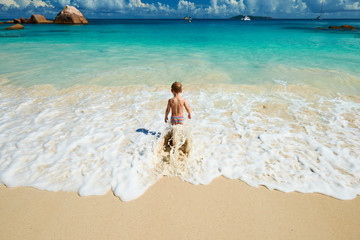 Two year old boy playing on beach