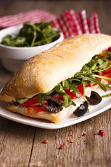Sandwich with olives, bell pepper and arugula