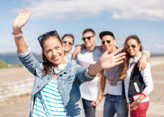 teenage girl with headphones and friends outside
