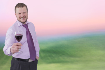 Businessman holding glass of wine with sunrise background